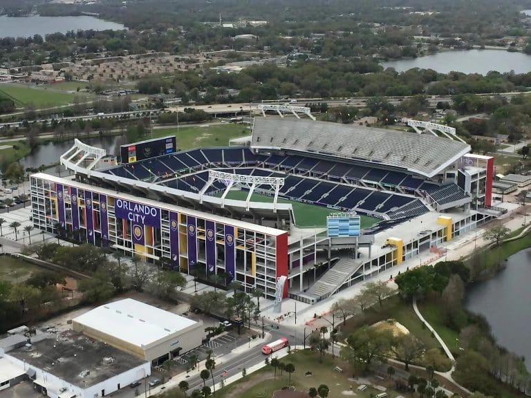 Aerial view of the citrus bowl with cars, buses, and Orlando City on the outside