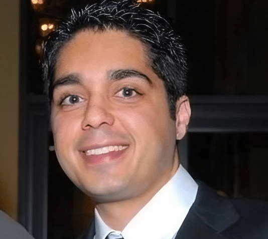 Businessman with dark hair smiling in a suit